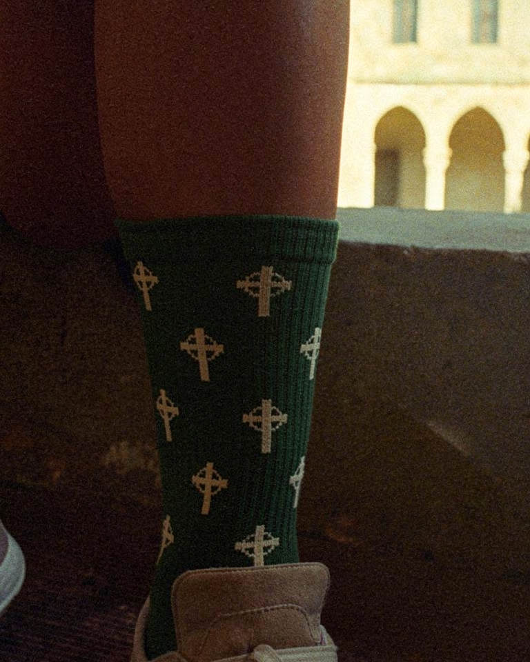 Calcetines con cruz celta en verde inglés, foto lifestyle en claustro — AMEN SOCKS