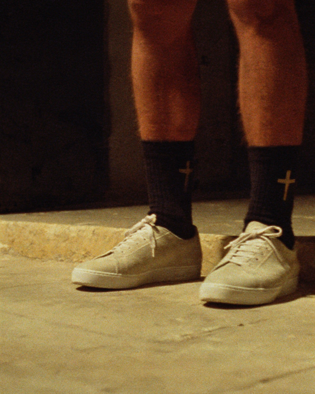 Calcetines con cruz dorada minimalista, lifestyle en capilla